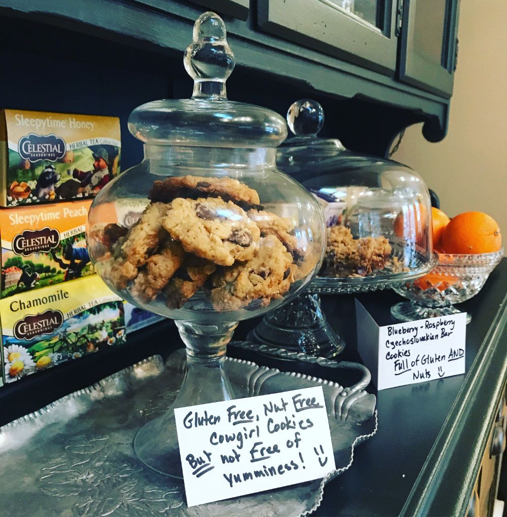 A jar of cookies labeled "Gluten free, nut free cowgirl cookies. But not free of yumminess!" and "Blueberry-raspberry Czechoslovakian bar cookies. Full of gluten and nuts!"