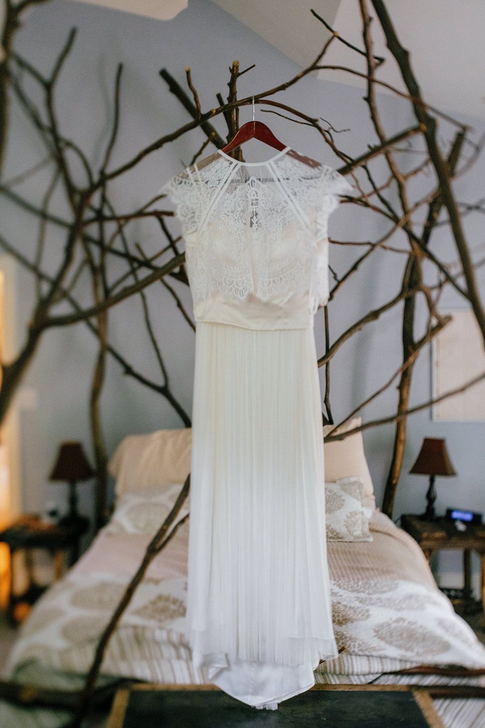 A white wedding gown hangs from the American Hornbeam bed frame.