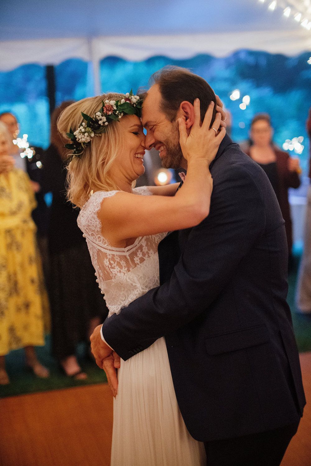 A couple dances and presses their foreheads together at wedding reception.