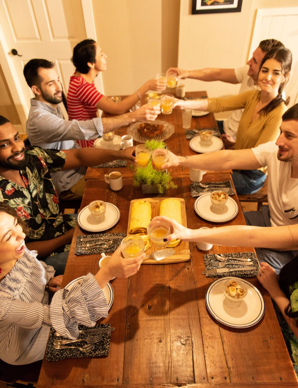 A group of guests cheers with each other while enjoying farm-to-table breakfast.