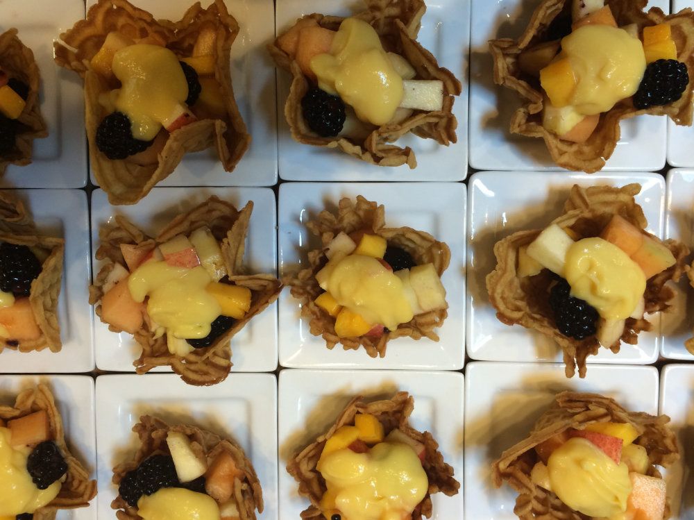 Pizzell waffle cookie cups filled with assorted fruit.