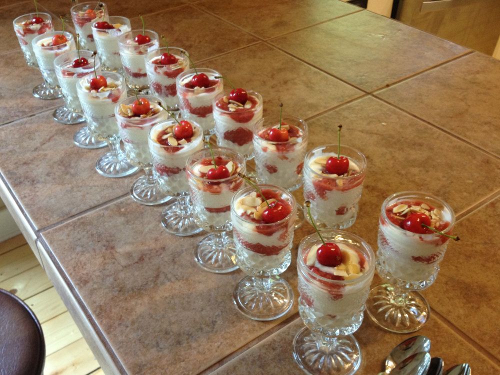 A line of yogurt parfaits filled with cherry sauce and topped with Goldberry grown cherries.