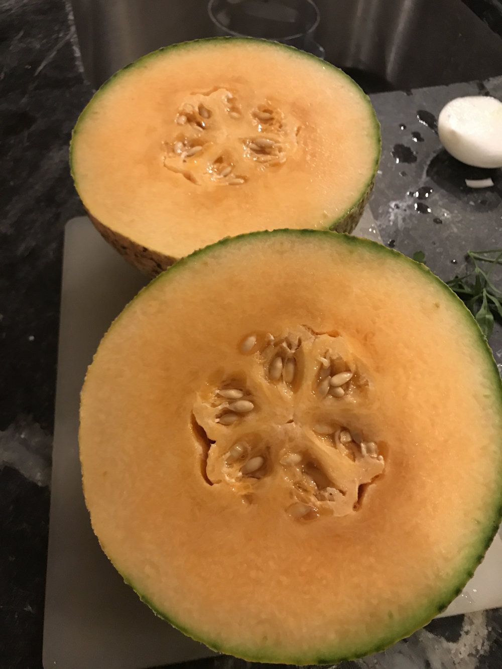 A home grown melon cut in half to see the beautiful orange interior.