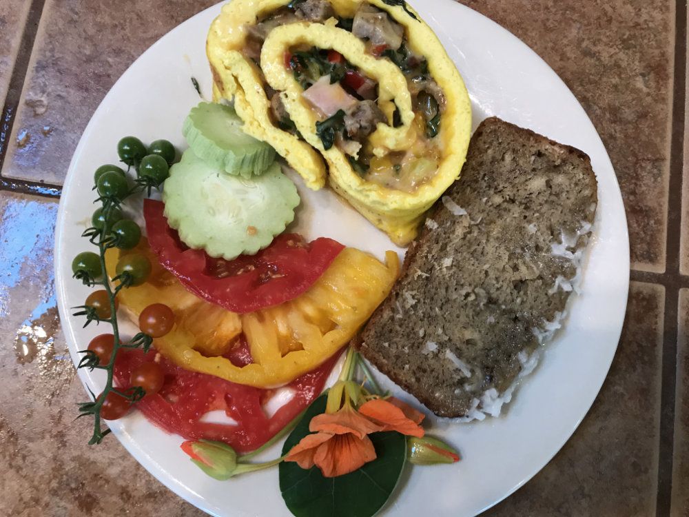 Home grown veggies and locally sourced sausage fill an egg roll up served with Goldberry grown heirloom tomatoes, cucumbers, and coconut zucchini bread.