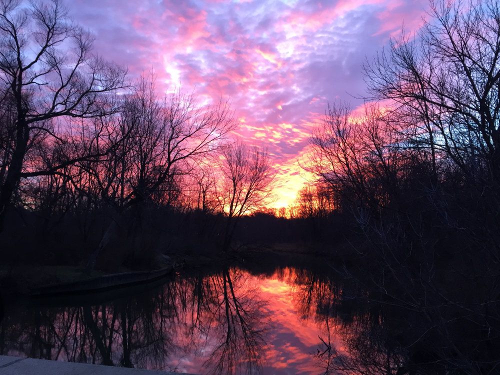 The sun sets vibrantly over the Galien river.