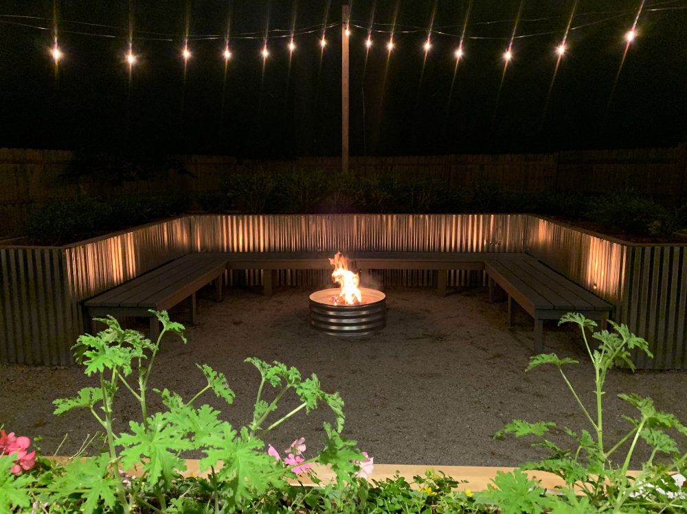 The firepit lights up the seating around it in the side-yard.