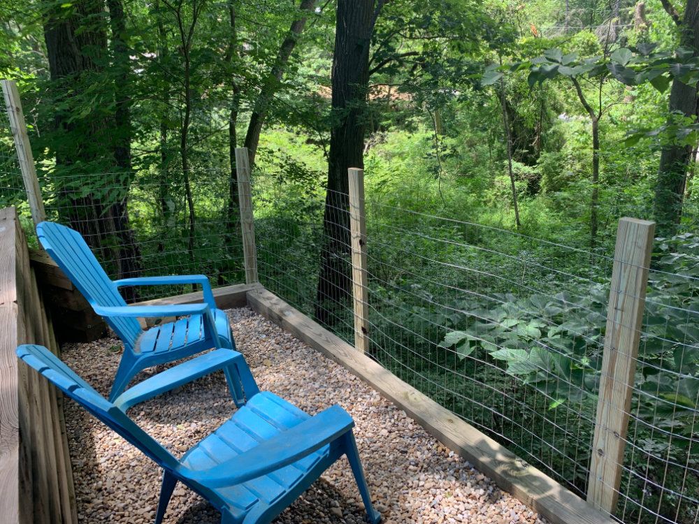 Two lounge chairs are sat looking out onto the ravine.