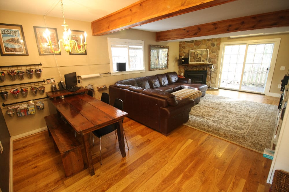 In this view of the family room, the activity table, benches, and school supplies can be seen next to the large leather couch.