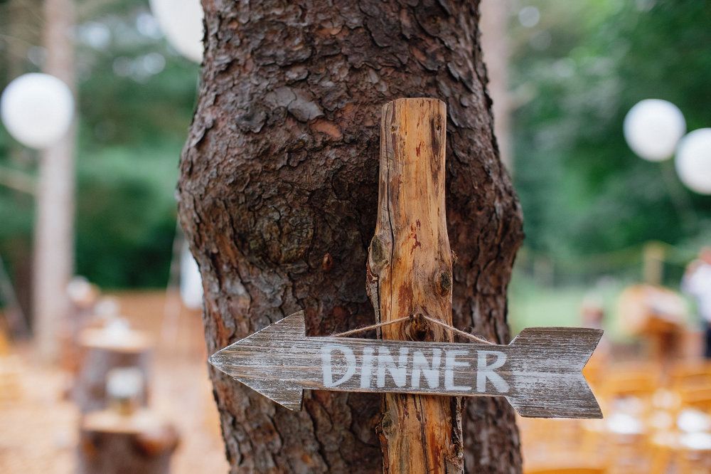 Hung on a tree, an arrow shaped sign reads "Dinner."