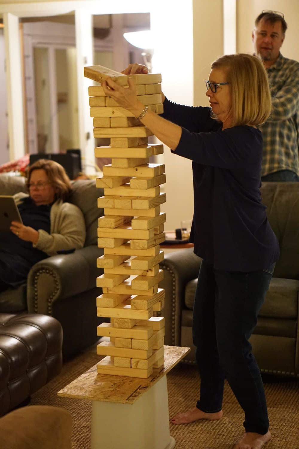 Woman attempts to move brick in a game of Giant Jenga.