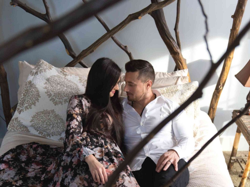 Female and Male couple on a bed looking into each others eyes