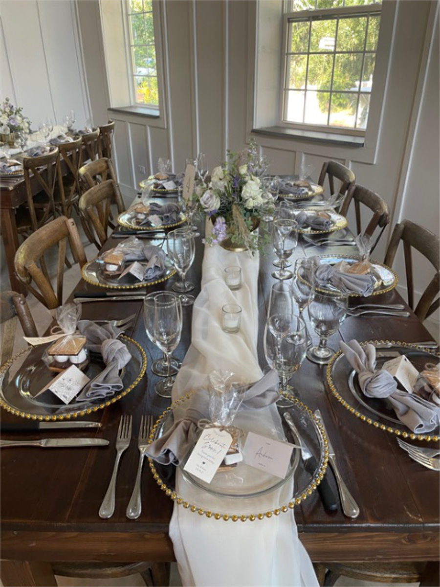 Table decorated in gold plates, flowers, and table runners for celebration.