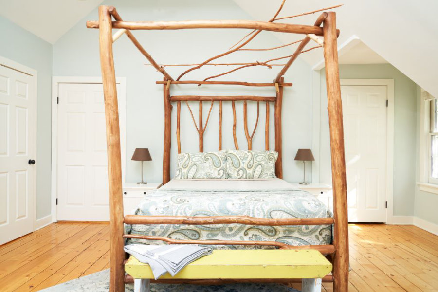 Direct view of Golden Maple's bed. There are nightstands on each side of the bed and a bench at the foot of the bed.