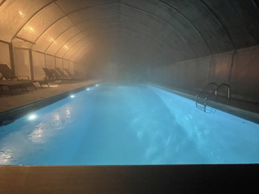 The heated pool steams on a winter night in the pool enclosure.
