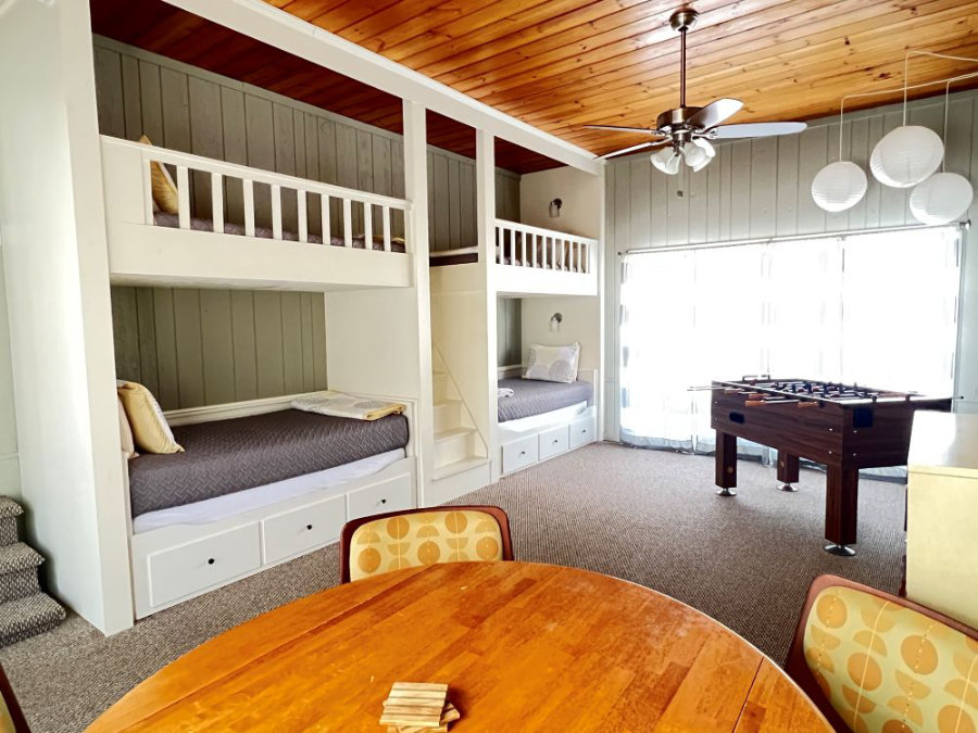 Bunkroom with 4 built-in twin beds, table and chairs, and foosball table.