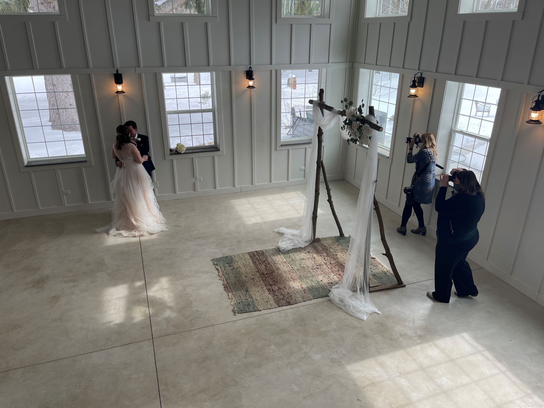 Shot from the loft, a photographer takes pictures of a couple on their wedding day.