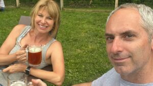 eric and julie seated outside at seedz brewery with steins of beer