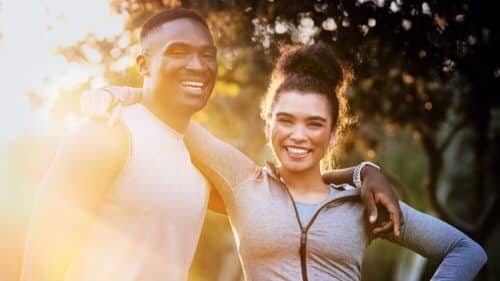smiling fit couple standing together outdoors