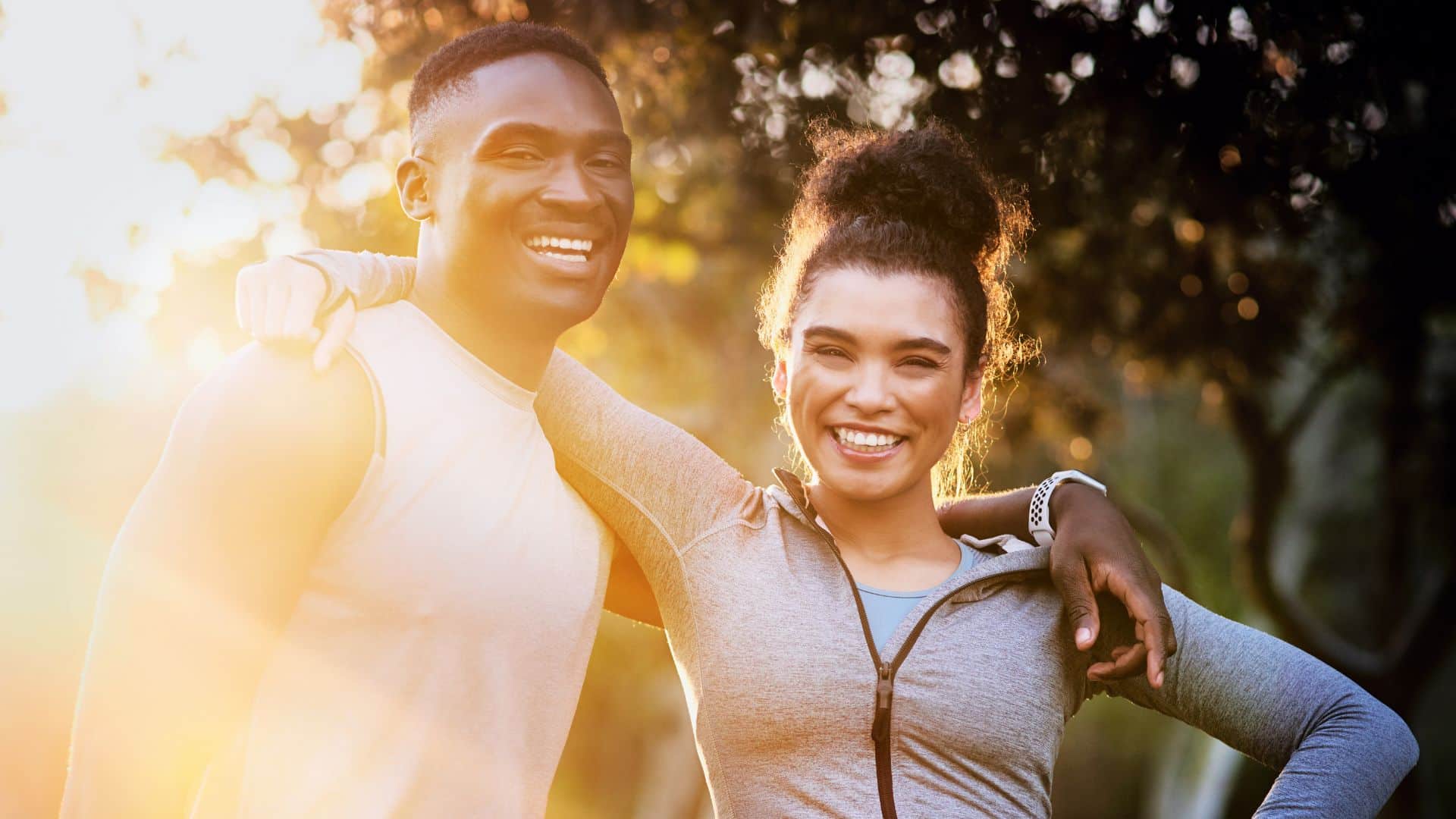 smiling fit couple standing together outdoors