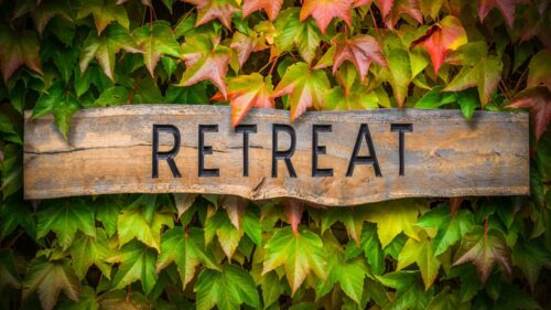 wooden retreat sign surrounded by maple leaves