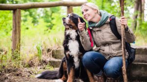 woman taking a break from hiking with her dog