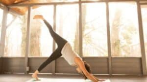 woman performing three-legged downward-facing dog yoga pose
