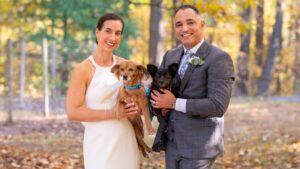 bride and groom holding their dogs among the fall trees at goldberry woods