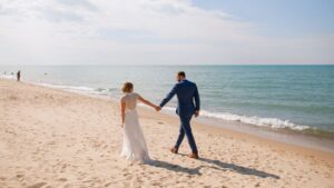 bride and groom walking along the beach on lake michigan after their goldberry woods wedding