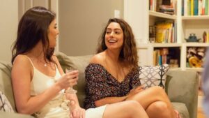 two ladies relaxing with drinks while sitting on a couch at goldberry woods
