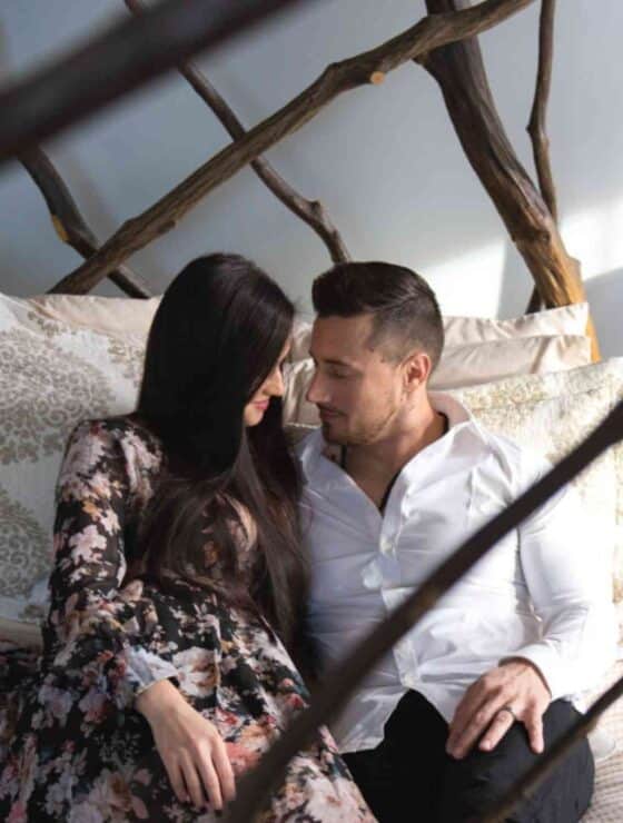 Female and Male couple on a bed looking into each others eyes