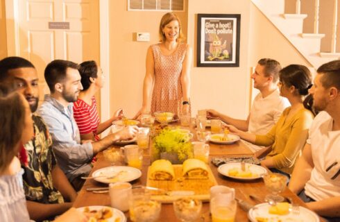 A group of men and women gathered at a dining room table for a meal