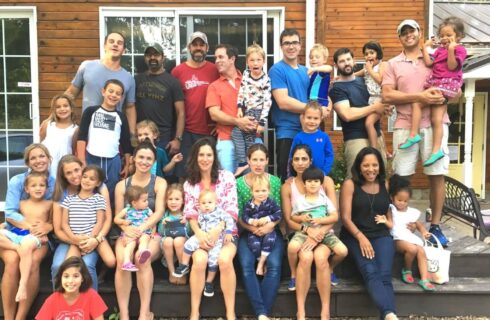 A large group of people with children gathered for a photo on a patio outside of a home