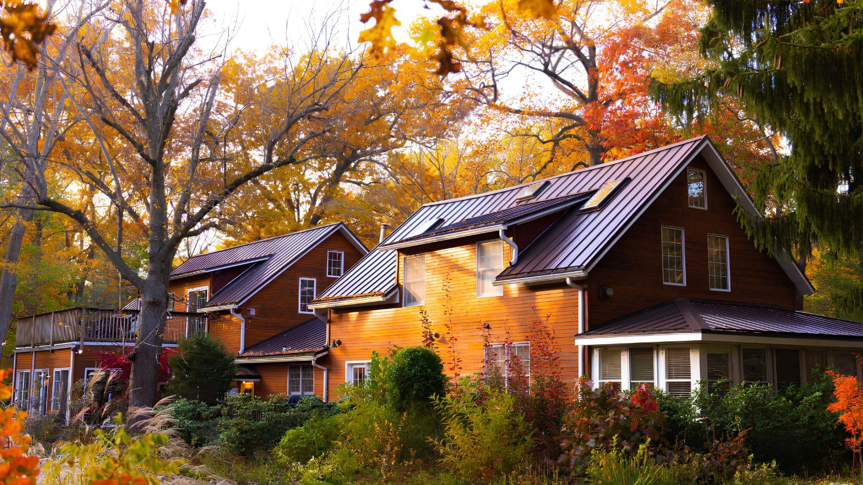 Exterior of the modern farmhouse Inn at Goldberry Woods bed and breakfast surrounded by colorful fall foliage in Union Pier, Michigan.