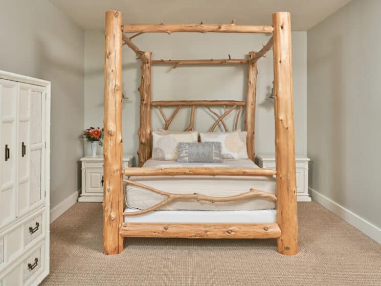 A spacious bedroom with a four-poster queen-size bed made of full-size cedar logs