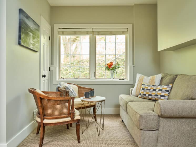 Bright sitting area with loveseat and two chairs by a large window