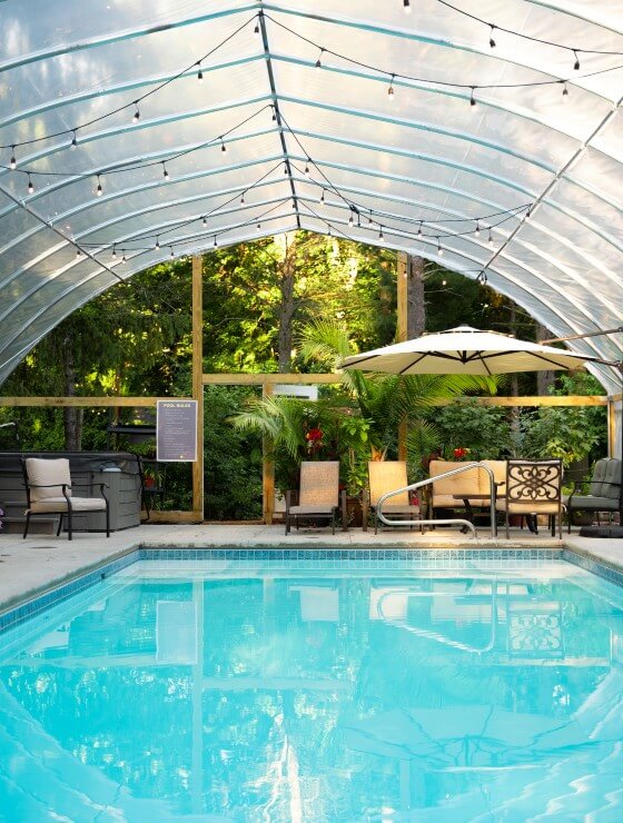 Outdoor pool area with large covering, string lights and patio furniture