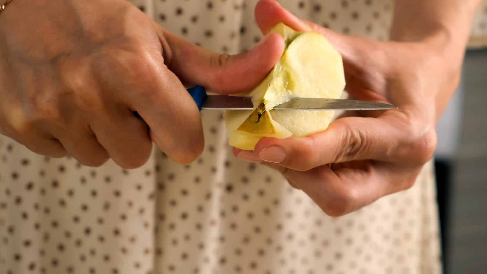 Close up of a guest peeling a fresh Michigan apple during an autumn weekend getaway stay at Goldberry Woods in Union Pier.