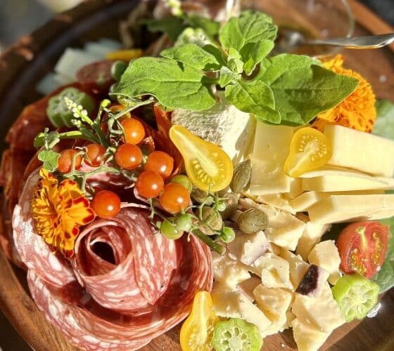 Charcuterie platter of meats, cheeses and tomatoes