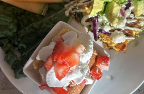 Southwestern Style Breakfast, Chorizo Hashbrown Quiche Topped with Avocado alongside a small piece of Tres Leches Cake topped with Whipped Cream and Fresh Strawberries
